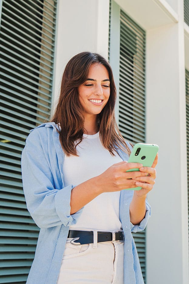 A woman checking the balance of her high yield online savings account on her phone.