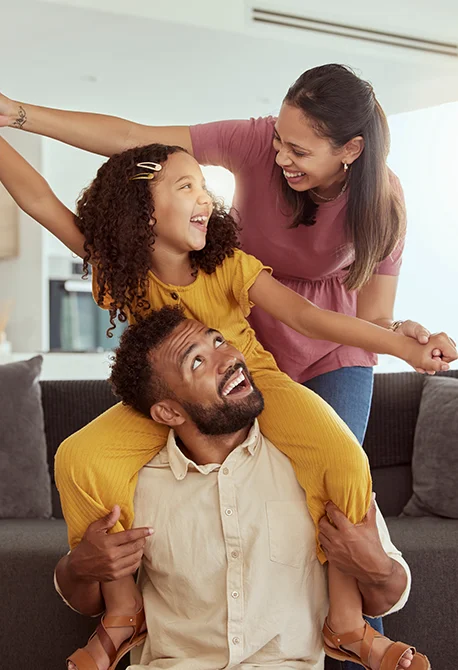 A family of three having fun at home while learning about credit union facts.
